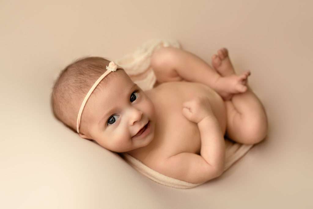 2 months old baby girl smiling to the camera