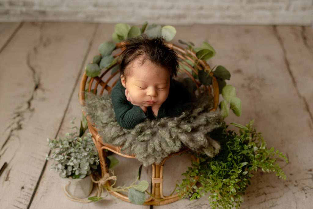 newborn baby boy in the newborn chair holding his head