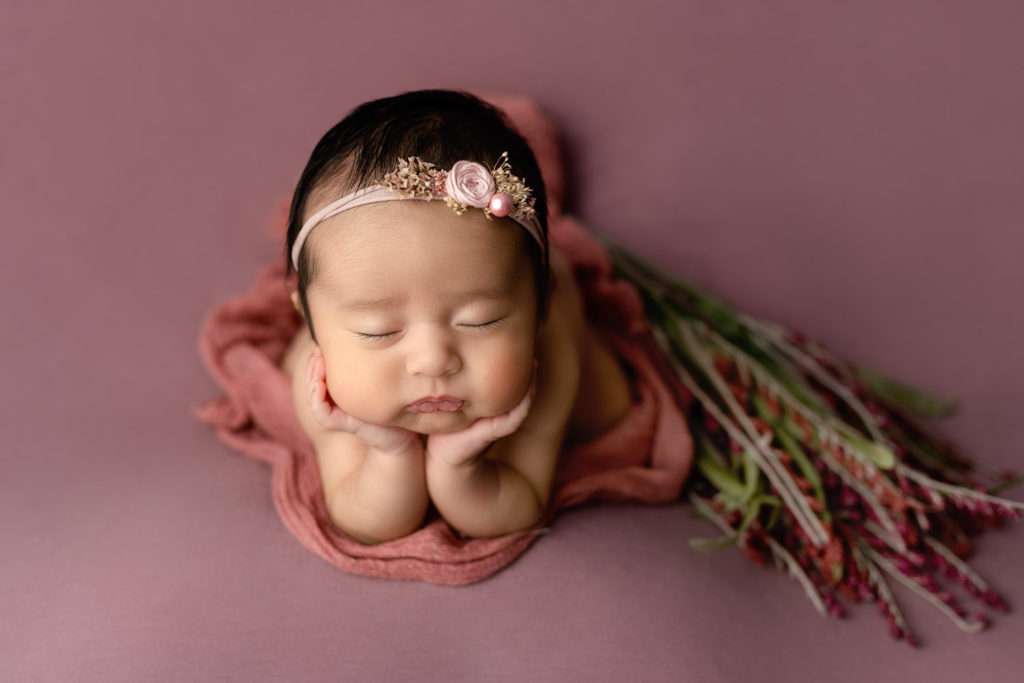 Newborn baby girl on a purple blanket