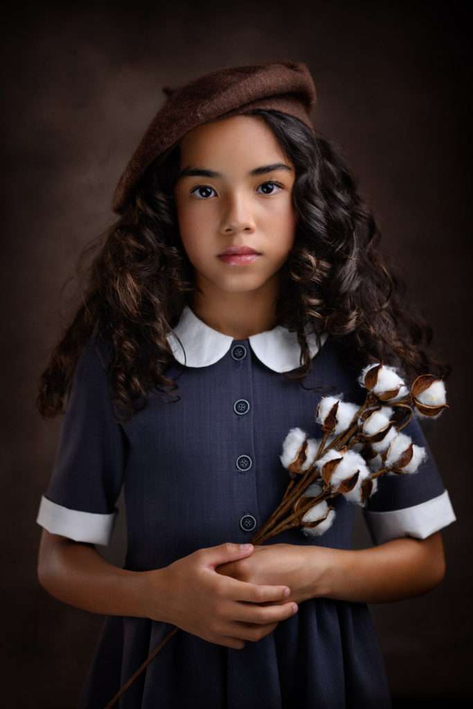 fine art studio portrait of a girl holding cotton flowers