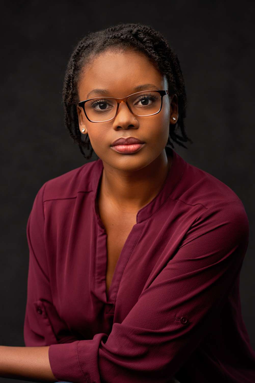 Headshot of a woman in glasses and in crimson blouse