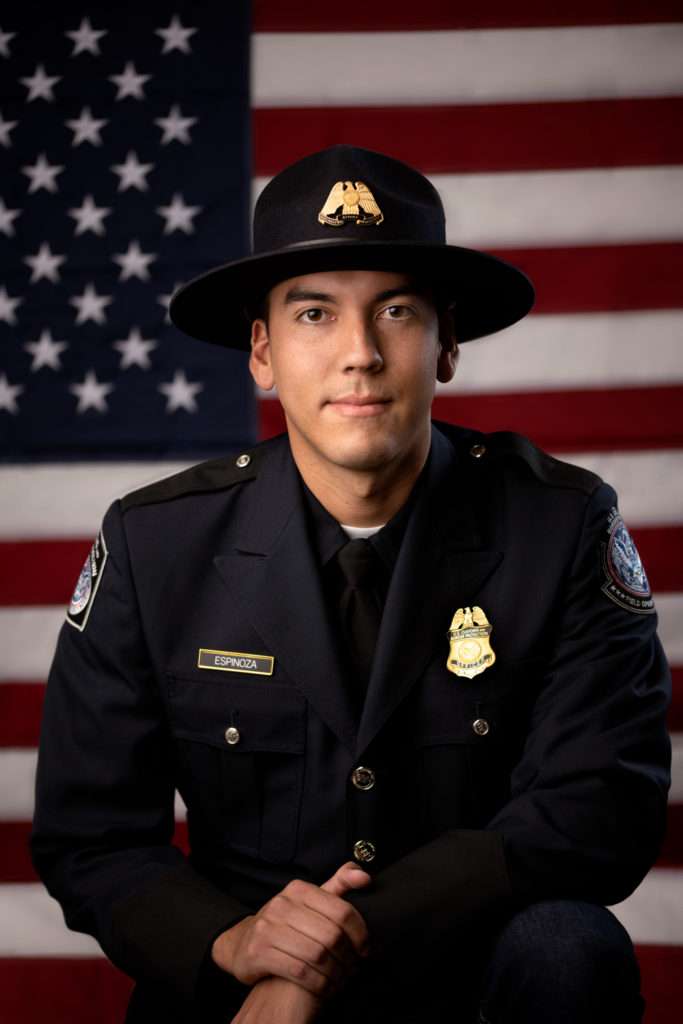 business headshot on a man wearing police uniform with american flag on the background by san diego headshot photographer