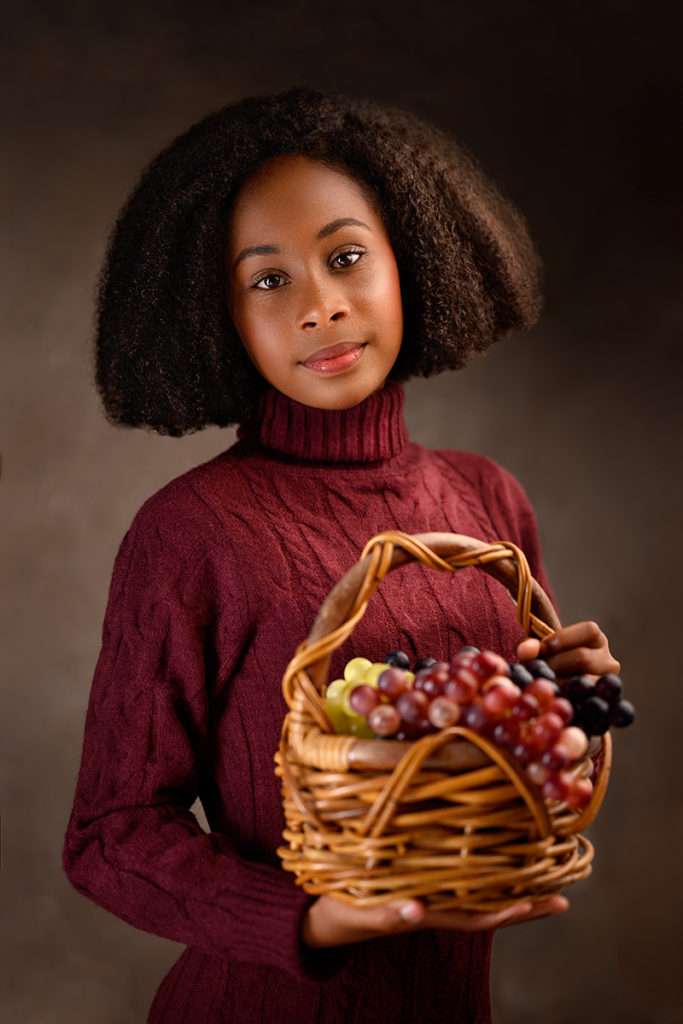 portrait of a african american girl holding basket with grapes by best san diego family photographer