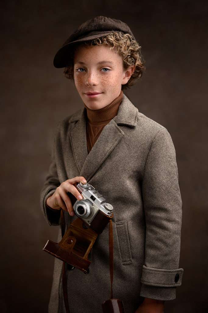 fine art portrait of a boy weating vintage coat and vintage camera by best san diego family photographer